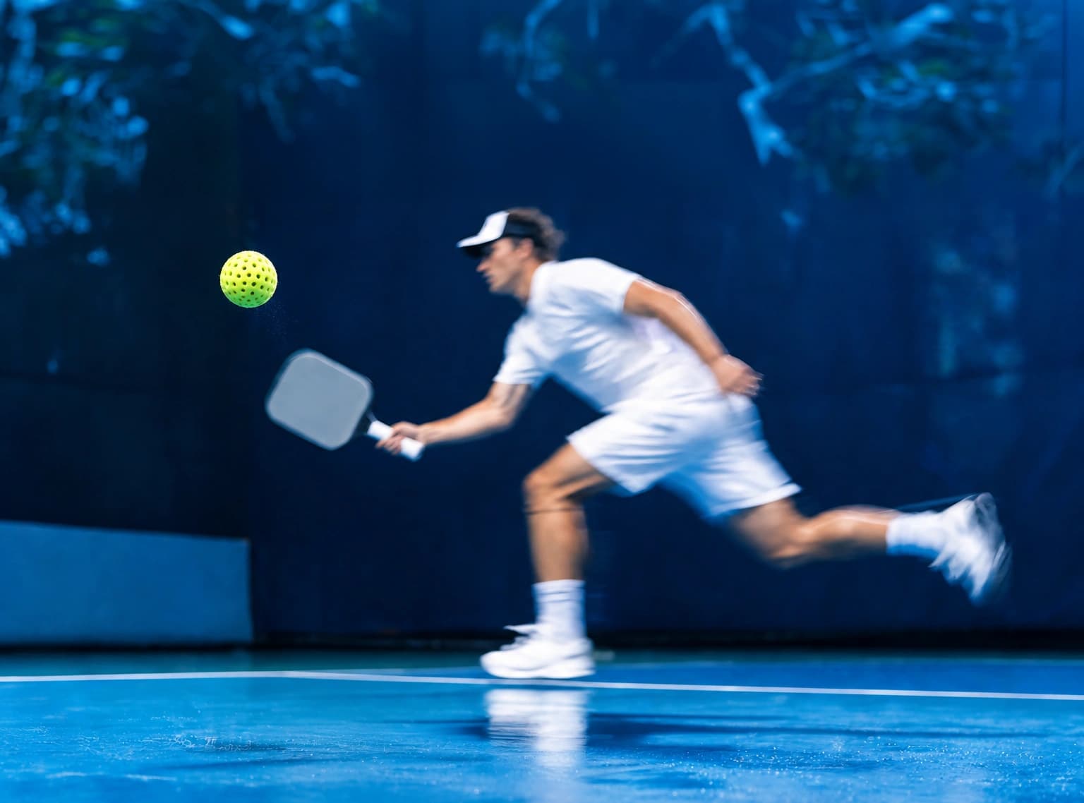 Pickleball player lunging for a shot on a blue court